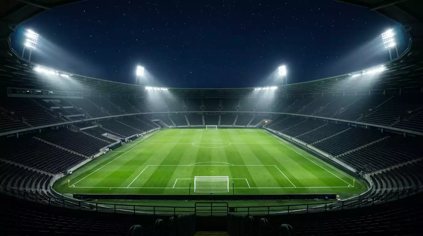 Estádio de futebol iluminado durante noite de Champions League com relvado verde